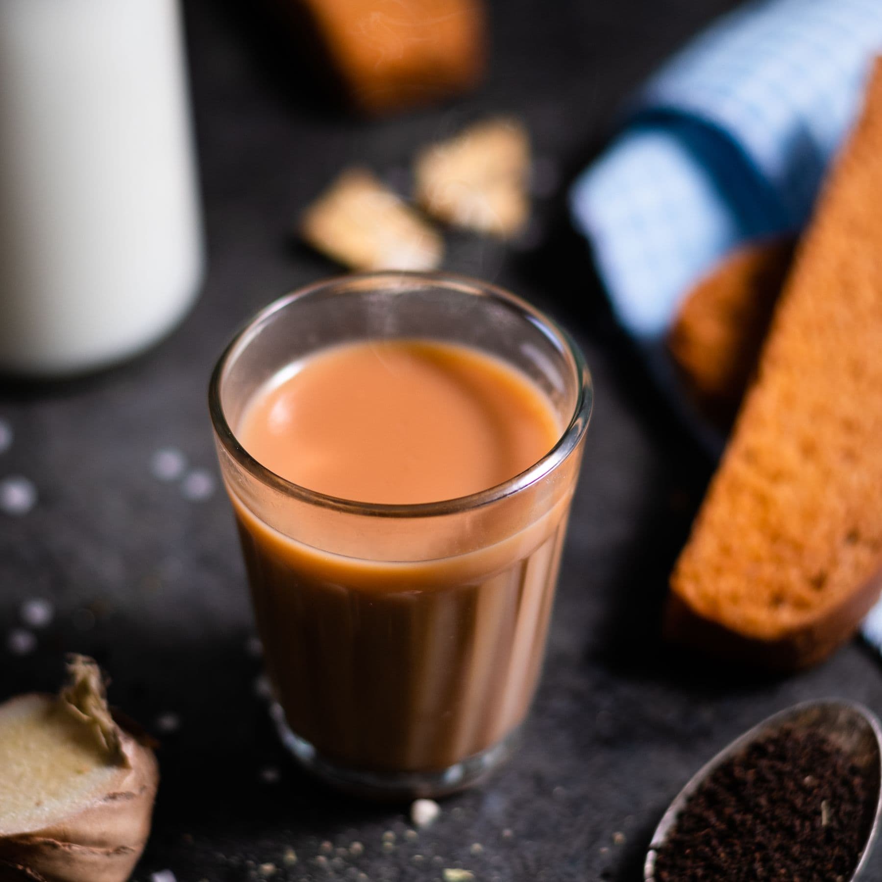 A glass of spiced chai with biscuits